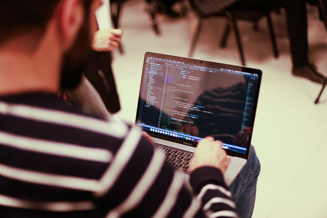 programmer coding on laptop